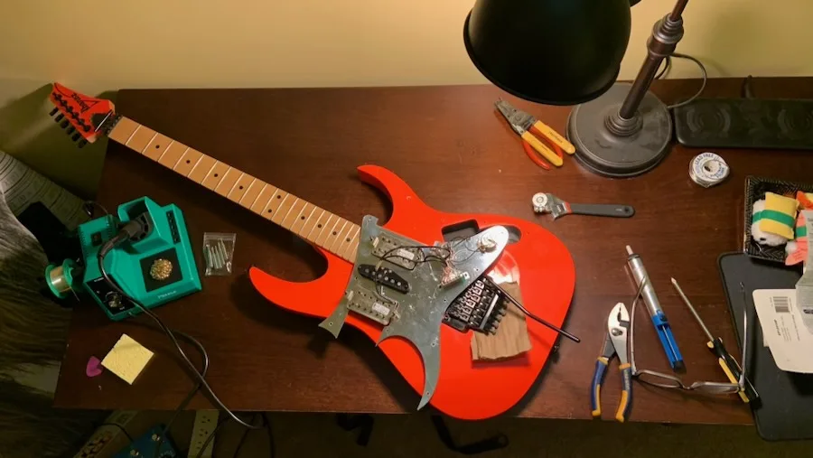 Disassembled guitar parts arranged on a workbench