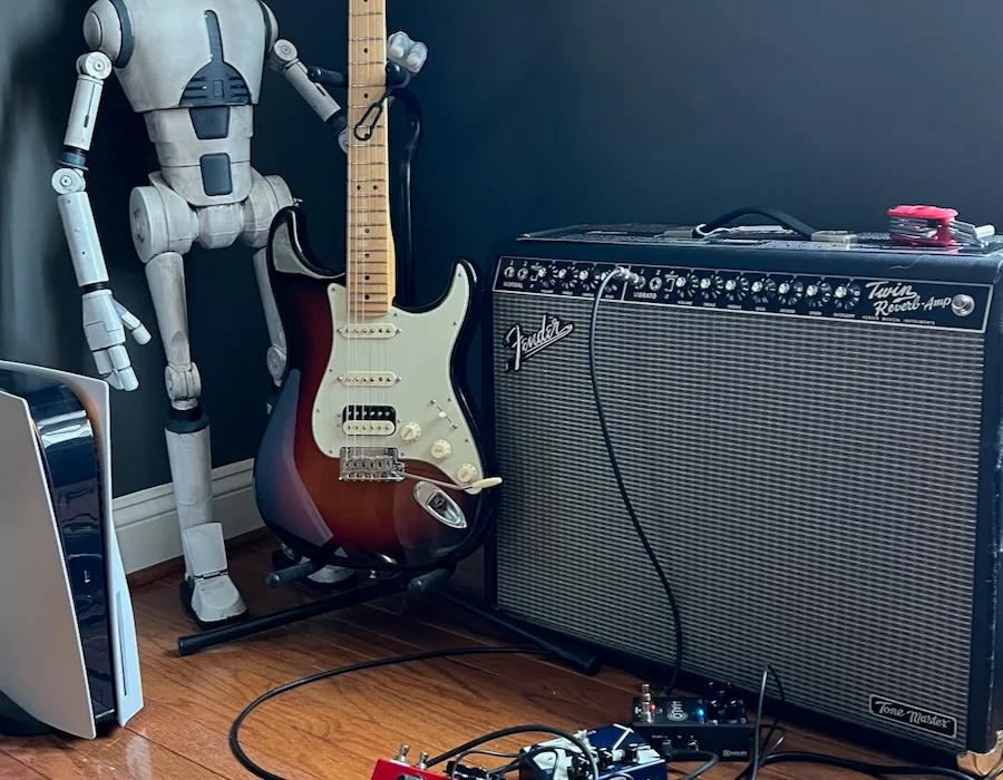 Droid figure beside a guitar and amplifier